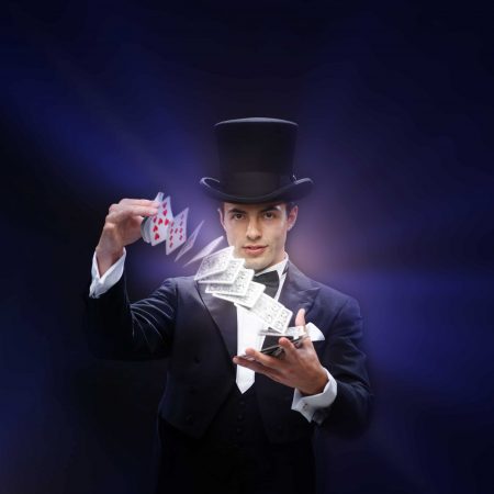 magic, performance, circus, gambling, casino, poker, show concept - magician in top hat showing trick with playing cards